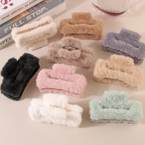 Pinces à cheveux en fausse fourrure en neuf couleurs assorties sur fond beige chaud