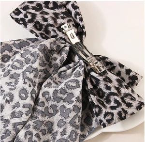 Close-up of leopard print bow hair clip with sturdy silver handmade metal spring clasp