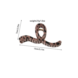 Detail view of large leopard print hair claw clip with twisted geometric design