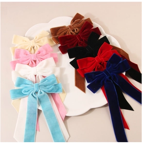 Detailed close-up of velvet bow hair clips with long streamers in nine elegant colors
