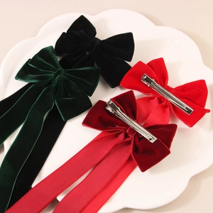 Elegant velvet bow hair clips with long streamers in four colors on a white plate
