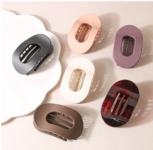 Barrettes à cheveux ovales mates de couleurs variées sur une assiette décorative