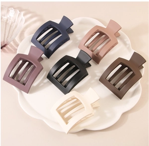 Set of six matte square hair claws in assorted colors on a white floral ceramic tray