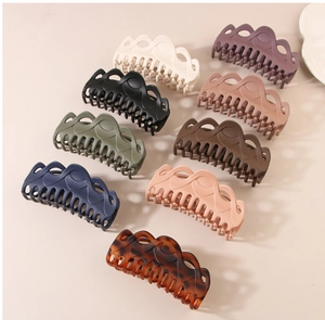 Detailed grid of nine large matte hair claws in various colors with wavy cutout design