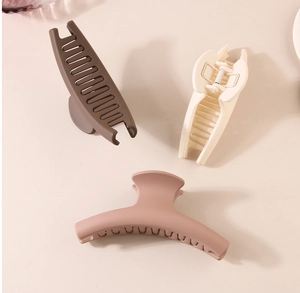 Three large matte hair claws in dark brown, cream, and pink for thick hair styling