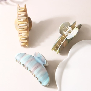 Elegant matte oval shark hair claw clips with marble texture for thick hair in white tray