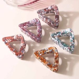 Detailed top view of medium hollow triangular hair claws in five marble patterns and colors
