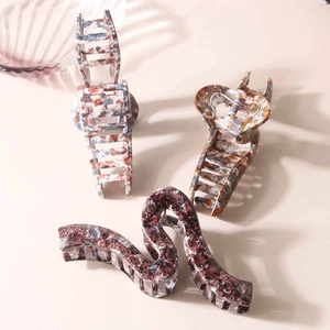 Three oversized acetate hair claws in leopard, blue-grey, and purple stone patterns