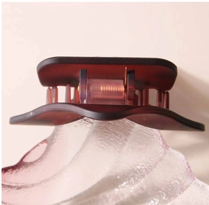 Gros plan sur la barrette géométrique montrant la texture givrée et le ressort métallique
