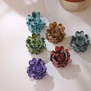 Set of six 4cm flower-shaped acrylic hair claws in assorted colors on a beige background