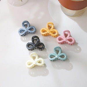 Set of six colorful bow-shaped hair clips with unique white splash paint patterns