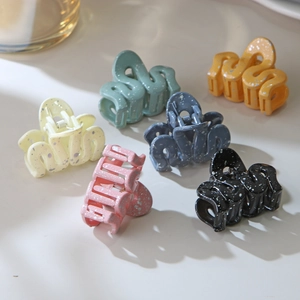 Macro shot of wavy hair clips with matte splatter texture and strong metal springs