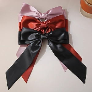 Elegant satin bow hair clips in pink, red, and black with long flowing ribbons