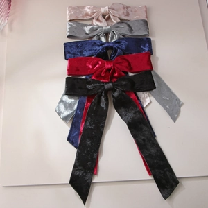 Flat lay of velvet bow hair clips in five colors showing fabric texture and drape