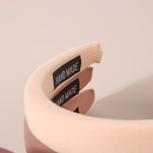 Détail de serre-têtes artisanaux en tissu montrant l'étiquette tissée et la texture
