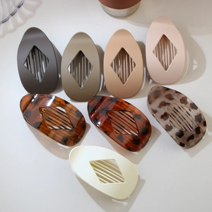 Detailed macro view showing seven assorted colors and finishes of diamond oval hair clips