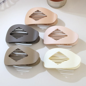 Detail of five matte rhombus hair clips in neutral Morandi colors with hollow design