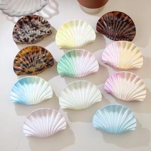 Flat lay of colorful seashell hair claws in acetate finishes with pearlescent textures