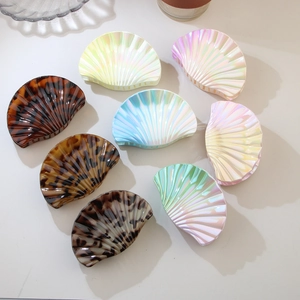 Detailed flat lay of shell-shaped hair claws in tortoiseshell and iridescent finishes