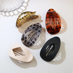 Detail of five assorted leopard print and matte resin hair clips in teardrop shapes