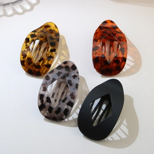 Close-up of leopard print hair clips with hollow diamond design and internal comb teeth