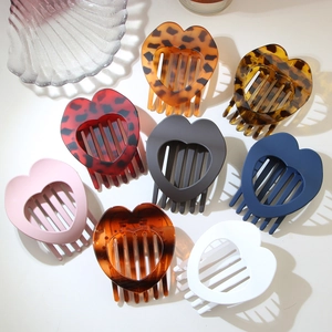 Vista piatta di otto fermagli per capelli a forma di cuore in leopardo e tinte unite