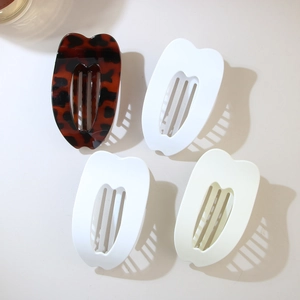 4-piece set of minimalist hair clips in tortoiseshell and cream finishes on beige background