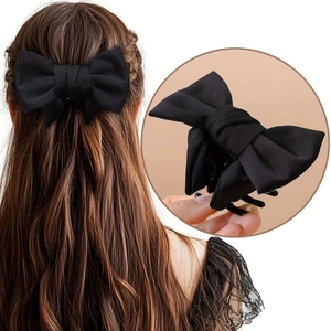 Détail d'une pince à cheveux nœud noir montrant la texture satinée et le mécanisme de prise