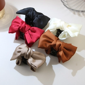 Vue détaillée de pinces à cheveux en satin aux tons noir, bordeaux, beige et champagne
