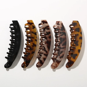 Detailed view of five tortoiseshell and black banana clips with non-slip comb teeth