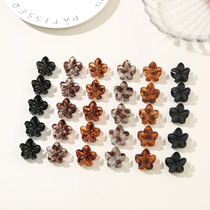 Flat lay of small floral hair claw clips in various matte and marble finishes