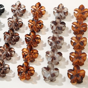 Detailed view of colorful flower claw clips with marble texture and polished finish