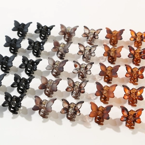 Macro shot of 12-piece butterfly hair claw set in matte and translucent Morandi colors