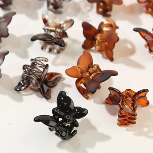 Detail of 12-piece butterfly mini hair claw clips in black, amber, and tortoiseshell finishes