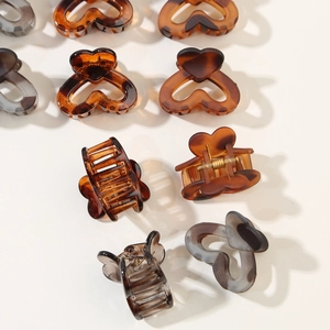 Detailed view of heart-shaped mini hair clips with marbled and tortoiseshell textures