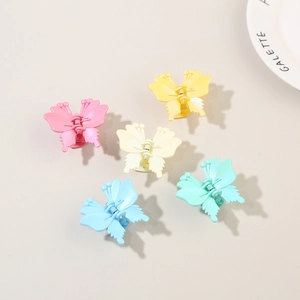 Detailed macro view of five macaron colored butterfly hair claws with matte plastic finish