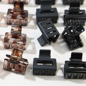 Detailed macro view of square hair claws in amber tortoise, matte black, and glossy finish
