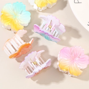 Vibrant gradient hibiscus flower hair claws in colorful candy tones for beach styling