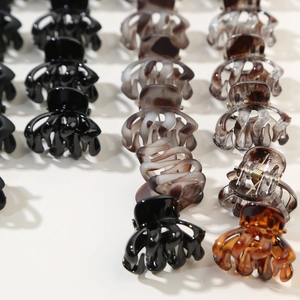 Close-up of assorted octopus hair claw clips in black, amber, and marble finishes