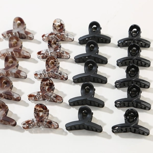 Detailed close-up showing macaron hair claw clips in matte black and tortoiseshell styles