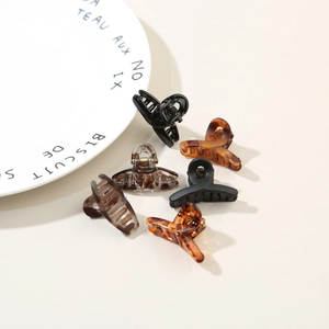 Close-up of assorted mini cross hair claws in tortoise shell and black resin finishes