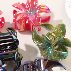 Dettaglio di fermagli per capelli a fiore di plumeria con finitura metallica cangiante e molla