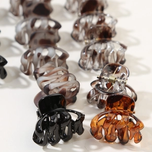 Detail of colorful mini octopus hair claws in marble and solid finishes with metal springs