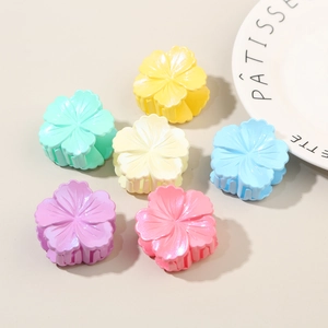 Flat lay of colorful flower hair claws in macaron tones with pearlescent resin finish