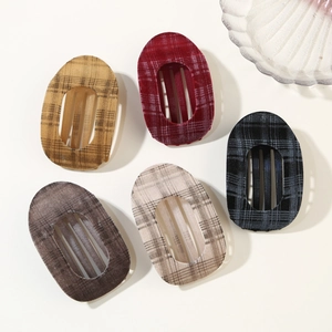 Flat lay of five vintage plaid velvet hair clips in assorted autumn colors with retro texture