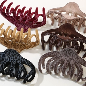 Detail view of large flocked hair claw clips in six colors with unique crackle patterns