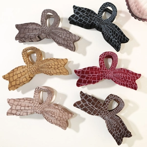 Detail view of large velvet bow hair claws with realistic animal texture in six rich colors