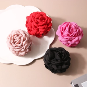 Détail de pinces à cheveux rose en tissu coloré avec accents léopard sur plateau céramique