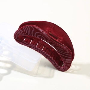Macro view of vintage burgundy flocked crescent claw clip with elegant wave patterns