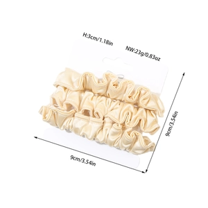 Three-piece set of satin silk scrunchies in champagne color on display card